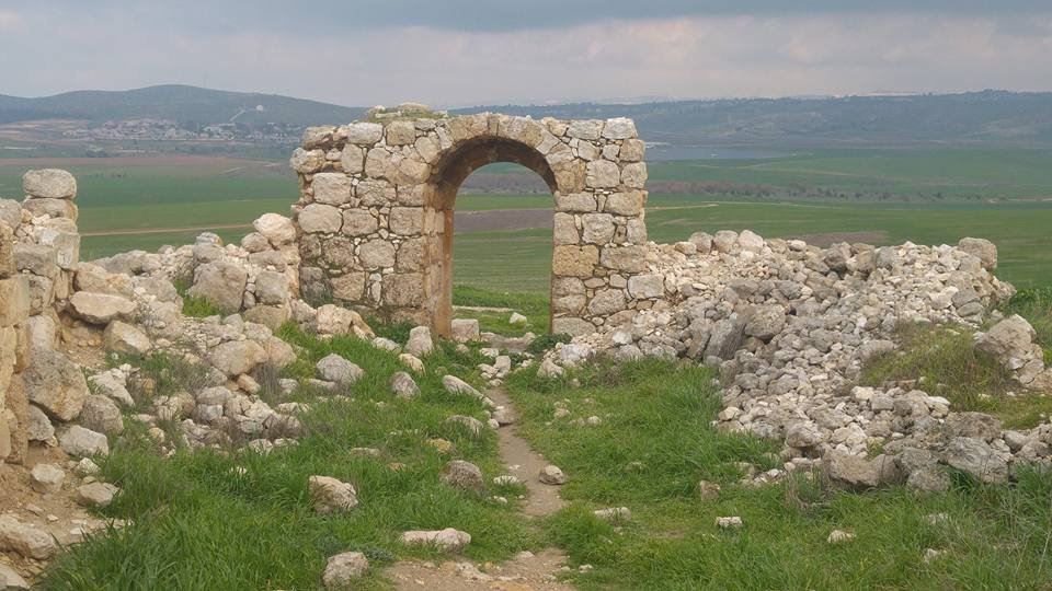 קשת אבן עתיקה בחורבת זעק, מול שדות ירוקים