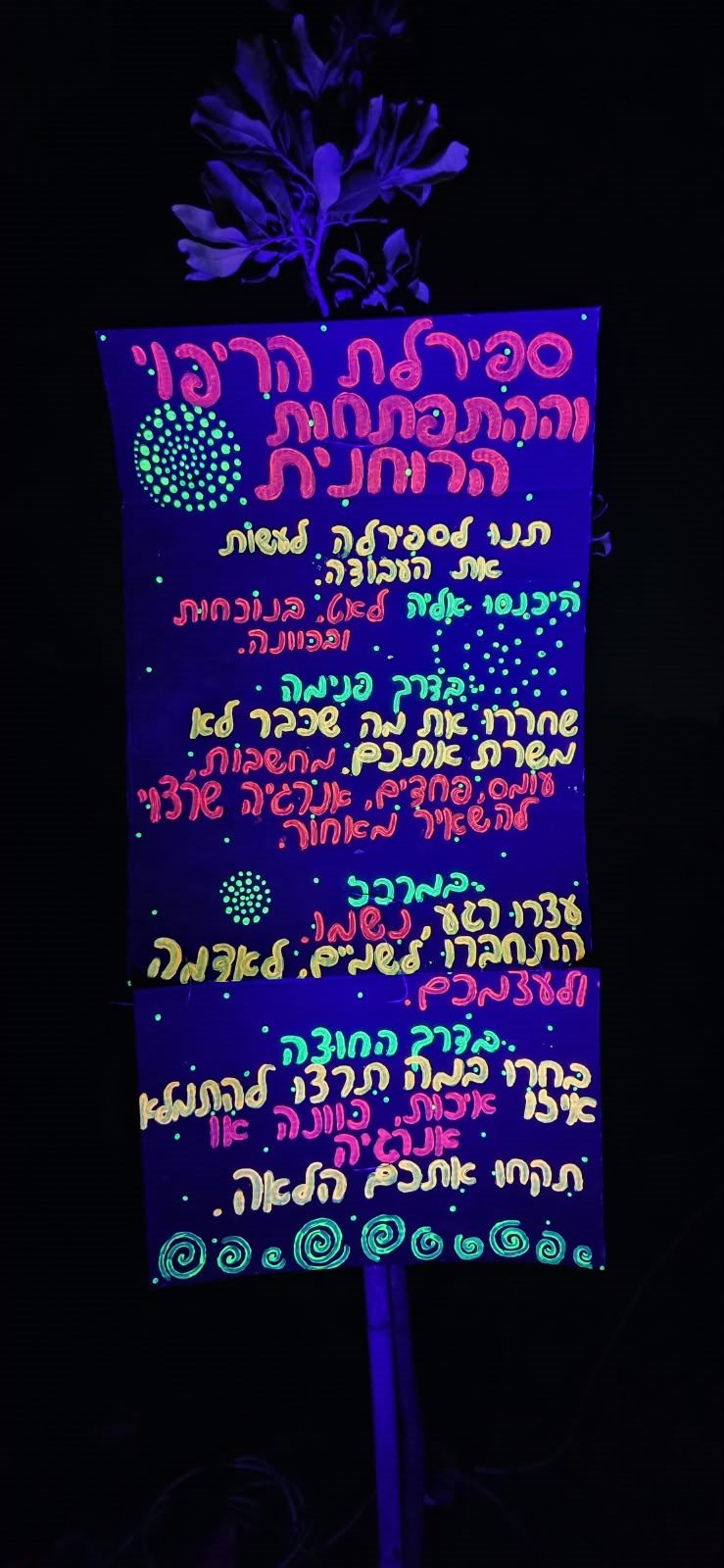 השלט של ספירלת הריפוי, זוהר באור שחור בלילה
